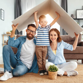 a family holding a folded poster board like it is their roof